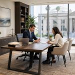 Personal injury attorney reviewing legal documents with injured client in modern Southern California law office, courthouse visible through window, professional and reassuring consultation scene.